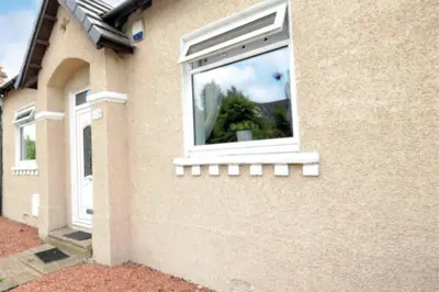 a window on the side of a building at Cheerful One bedroom cottage with parking space. in Glasgow