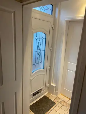 a hallway with a door with a stained glass window at Cheerful One bedroom cottage with parking space. in Glasgow