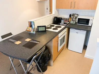 a small kitchen with a counter and a stove top oven at Glasgow City Centre Studio Apartment in Glasgow