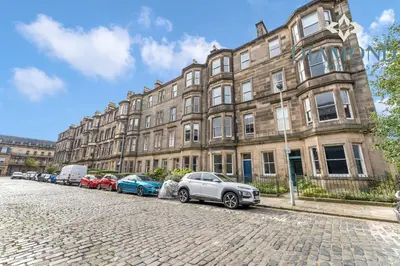 a row of cars parked in front of a building at Spacious 1 Bed Ground Floor Apartment with Garden in Edinburgh