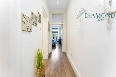 a hallway with white walls and a plant at Spacious 1 Bed Ground Floor Apartment with Garden in Edinburgh