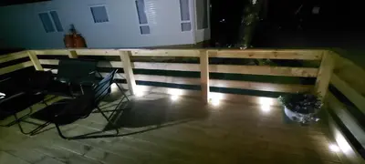 a deck with two chairs and a fence at Westmorland 32 caravan in Ballantrae