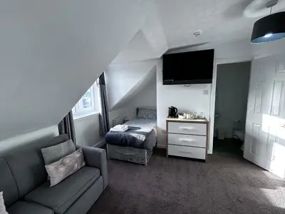 a living room with a couch and a bed at DunMoore Guesthouse in Oban