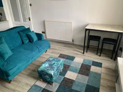 a living room with a blue couch and a table at The Cochno Flat, Clydebank in Dalmuir