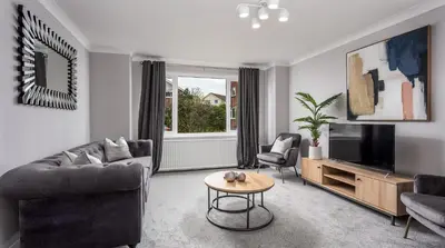 a living room with a couch and a tv and a table at Leeward House - Donnini Apartments in Ayr