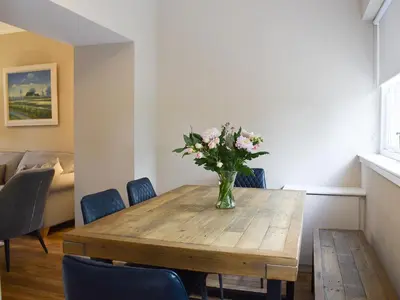 a dining room table with a vase of flowers on it at Craigmore View-Uk34220 in Aberfoyle