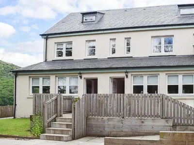 a white house with a wooden fence in front of it at Craigmore View-Uk34220 in Aberfoyle