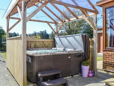 a hot tub under a wooden pergola at Kinvara in Stranraer