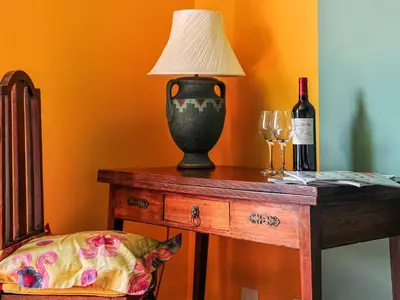 a table with a lamp and a bottle of wine at Holst Apartment in Newton Stewart