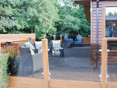a sliding glass door of a patio with furniture at Riverside Lodge in Auchterarder
