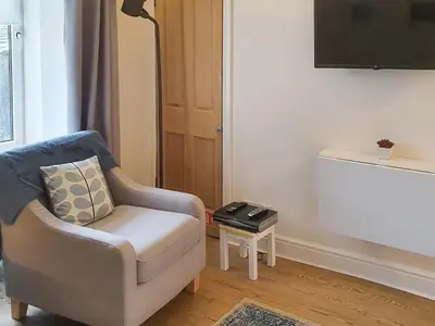 a living room with a chair and a table at Osocozee in Millport