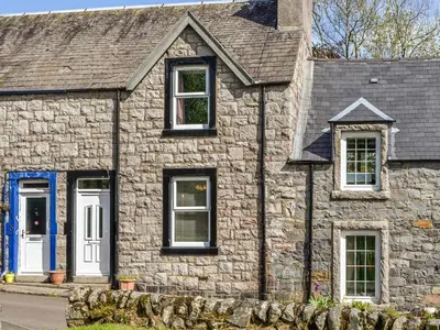 an old stone house with a blue door at Sunnyside in New Galloway