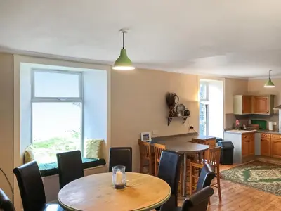 a kitchen and dining room with a table and chairs at Ballygroggan Farmhouse - Uk35208 in Machrihanish