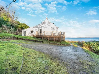 a house on a hill next to the water at The Creagan in Corrie