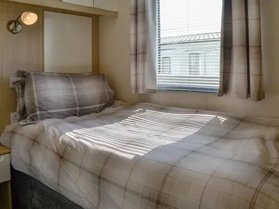 a bed in a small room with a window at Loch View in Kirkcolm