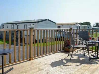 a wooden deck with two chairs and a table on it at Loch View in Kirkcolm