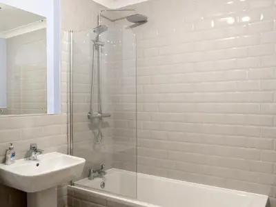 a white bathroom with a sink and a shower at The Barn in Fintry