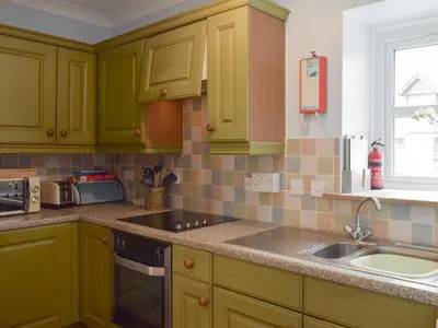 a kitchen with green cabinets and a sink at The Barn in Fintry