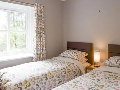 two twin beds in a room with a window at The Barn in Fintry