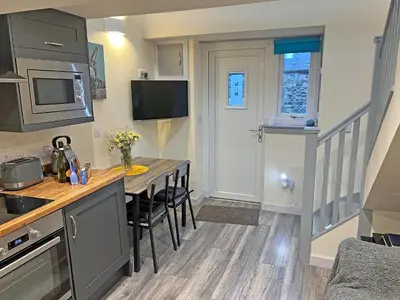 a kitchen with a table and chairs in a room at Uk7384 - The Hayloft in Newmilns