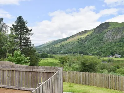 a wooden fence with mountains in the background at Faodail-Uk34218 in Aberfoyle