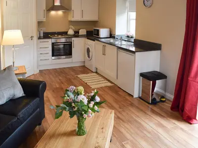 a kitchen and living room with a vase of flowers on a table at Faodail-Uk34218 in Aberfoyle
