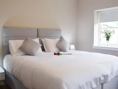 a white bed with flowers on top of it at Faodail-Uk34218 in Aberfoyle