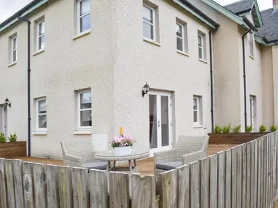 a patio with chairs and a table in front of a house at Faodail-Uk34218 in Aberfoyle