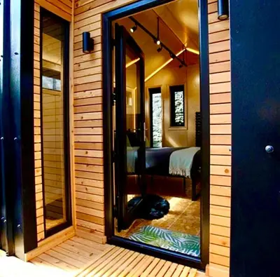 a reflection of a room with a bed and a mirror at Trossachs Barn & Cabin - boutique B&B in Port of Menteith
