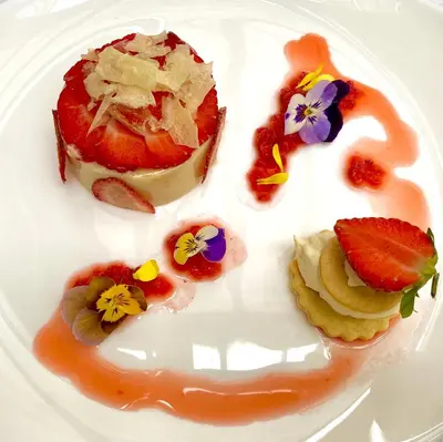 a white plate with a dessert with flowers on it at Victoria Square & The Orangery in Stirling