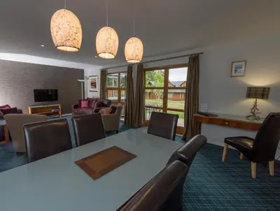 a living room with a table and chairs at Loch Lomond Waterfront Luxury Lodges in Balmaha