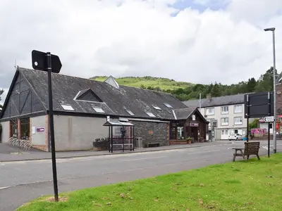 a building with a black roof on a street at Fascadail-Uk34219 in Aberfoyle