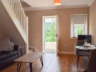 a living room with a couch and a table and a window at Fascadail-Uk34219 in Aberfoyle