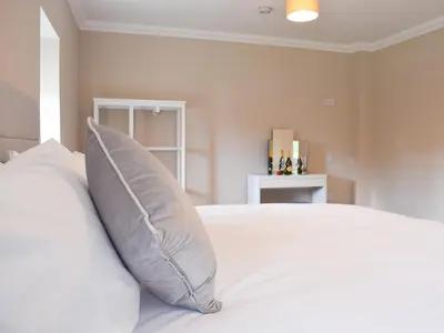 a bedroom with a white bed with a pillow at Fascadail-Uk34219 in Aberfoyle