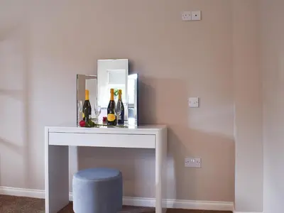 a white table with a mirror and bottles on it at Fascadail-Uk34219 in Aberfoyle