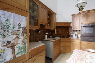 a kitchen with wooden cabinets and a christmas picture on the door at Quirky, West End, Edinburgh House in Edinburgh