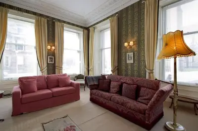 a living room with two red couches and a lamp at Quirky, West End, Edinburgh House in Edinburgh