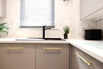 a white kitchen with a sink and a window at JOIVY Modern 1 bed Flat in West End, close to Princes Gardens in Edinburgh