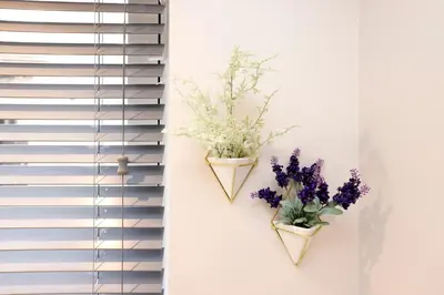 two vases with flowers on a wall next to a window at JOIVY Modern 1 bed Flat in West End, close to Princes Gardens in Edinburgh