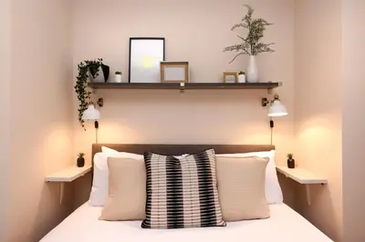 a bedroom with a bed with two shelves on the wall at JOIVY Modern 1 bed Flat in West End, close to Princes Gardens in Edinburgh