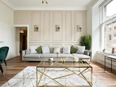 a living room with a couch and a glass table at Large Blythswood Residence in Glasgow