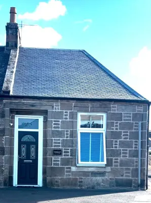 a brick house with a black door and a window at Cosy Cottage in Stirling