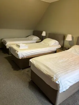 two twin beds in a room with two lamps at The Barn Lodge in Stirling