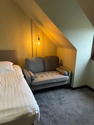 a room with a couch in the corner of a bedroom at The Barn Lodge in Stirling
