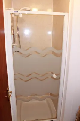 a shower with a glass door in a bathroom at The Barn Lodge in Stirling