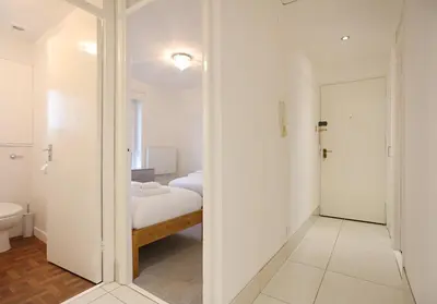 a white room with a bed and a mirror at The South Maybury Residence in Edinburgh