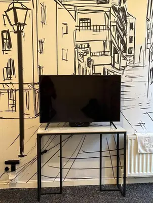 a tv sitting on a table in front of a wall at Central Glasgow Apt - Sleeps 2 & FreeParking During Weekend in Glasgow