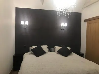 a bedroom with a bed with a black wall at The Stables near Glasgow in Balmore