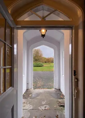 an entry way to a house with leaves on the ground at Park of Drumquhassle in Glasgow