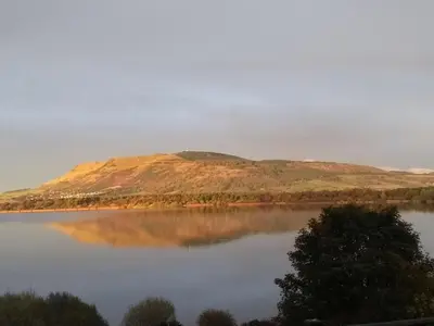 a view of a mountain reflecting in a lake at Chalet Loch Leven Lodge 12 by Interhome in Kinross